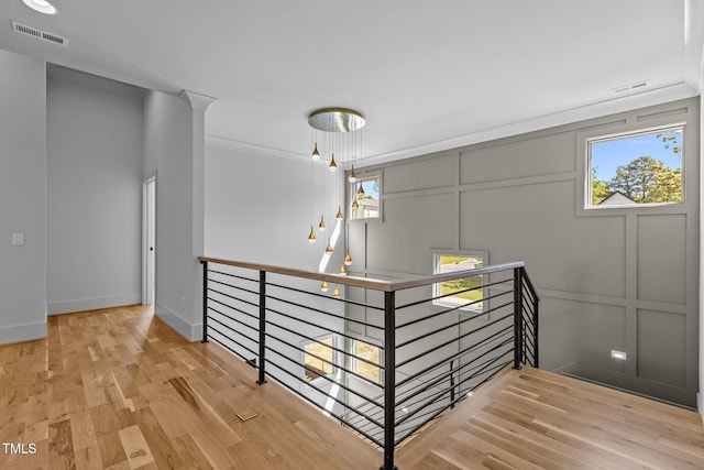 staircase with a decorative wall, wood finished floors, and baseboards