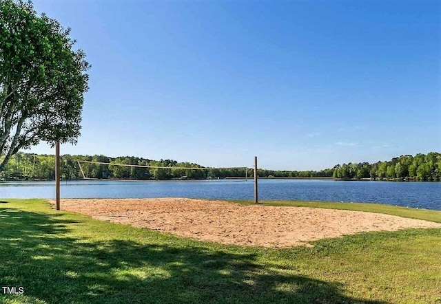 surrounding community featuring a yard, volleyball court, and a water view