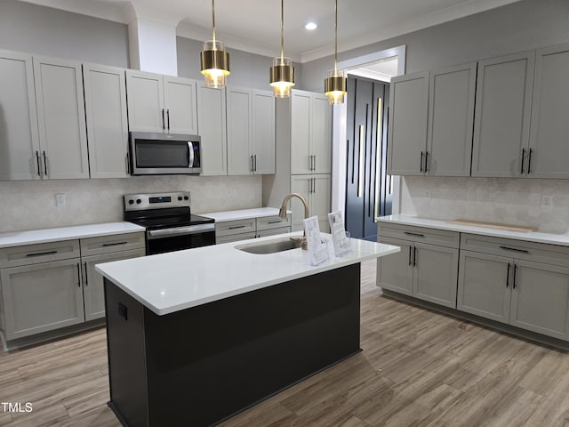 kitchen with crown molding, light countertops, light wood-style flooring, stainless steel appliances, and a sink