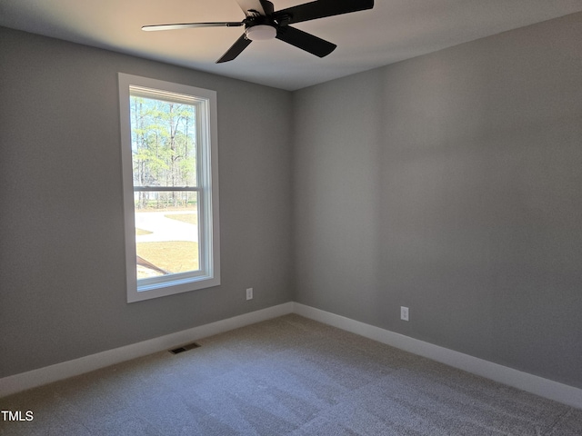 unfurnished room featuring visible vents, a ceiling fan, carpet, and baseboards