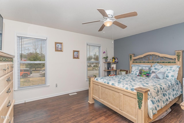 bedroom featuring ceiling fan, multiple windows, and dark hardwood / wood-style floors