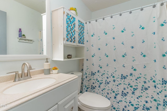 bathroom featuring curtained shower, vanity, and toilet