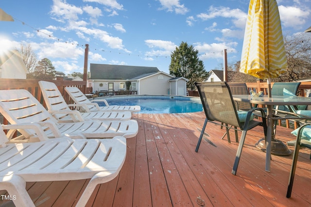 view of pool featuring a wooden deck and an outbuilding