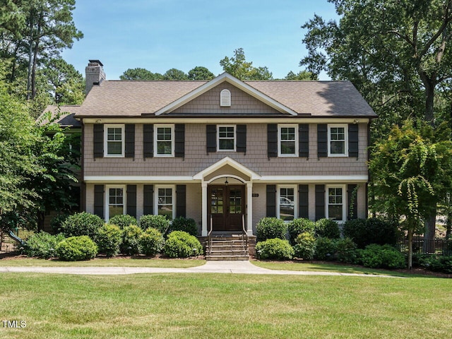 view of front of property with french doors and a front lawn