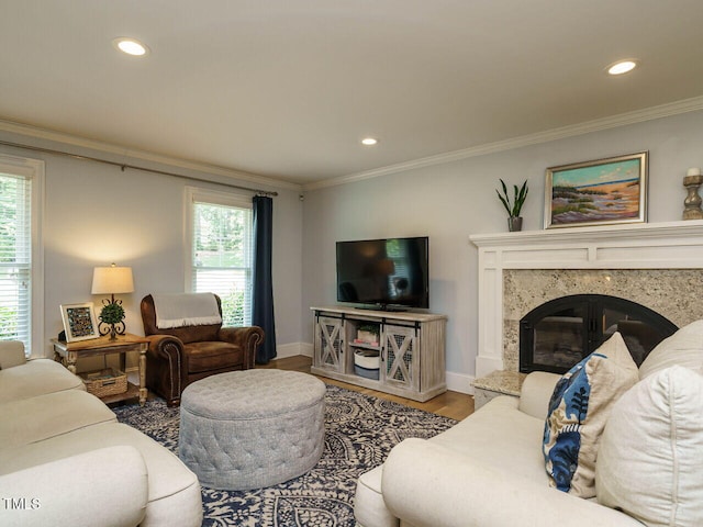 living room featuring a high end fireplace, crown molding, and hardwood / wood-style flooring