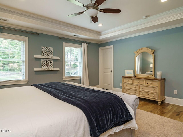 bedroom featuring ceiling fan, crown molding, light hardwood / wood-style flooring, and multiple windows