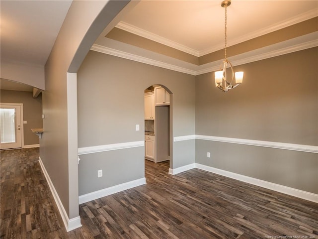 empty room with dark hardwood / wood-style floors, crown molding, and a chandelier