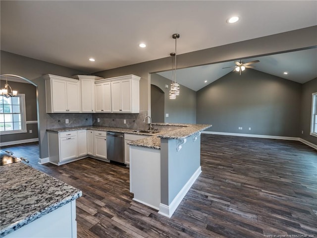 kitchen with white cabinets, vaulted ceiling, dishwasher, backsplash, and hanging light fixtures