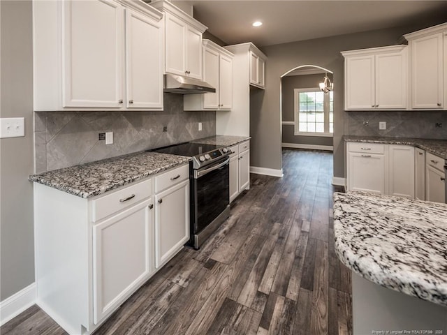 kitchen featuring stainless steel range with electric stovetop, white cabinetry, and light stone counters