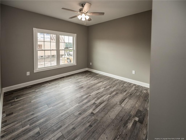 spare room with dark wood-type flooring and ceiling fan