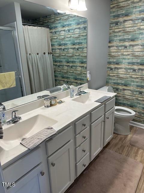 bathroom with hardwood / wood-style flooring, vanity, toilet, and walk in shower