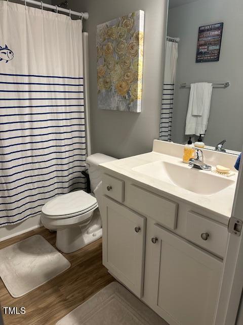 bathroom featuring vanity, hardwood / wood-style floors, a shower with shower curtain, and toilet