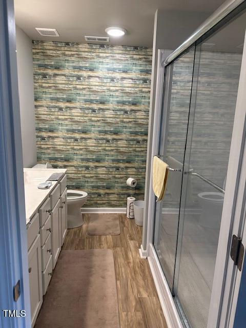 bathroom featuring vanity, an enclosed shower, wood-type flooring, and toilet