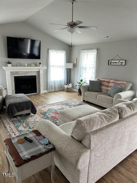 living room featuring ceiling fan, dark hardwood / wood-style floors, and vaulted ceiling