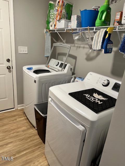 clothes washing area featuring independent washer and dryer and light wood-type flooring