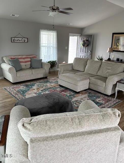 living room with hardwood / wood-style flooring, lofted ceiling, and ceiling fan