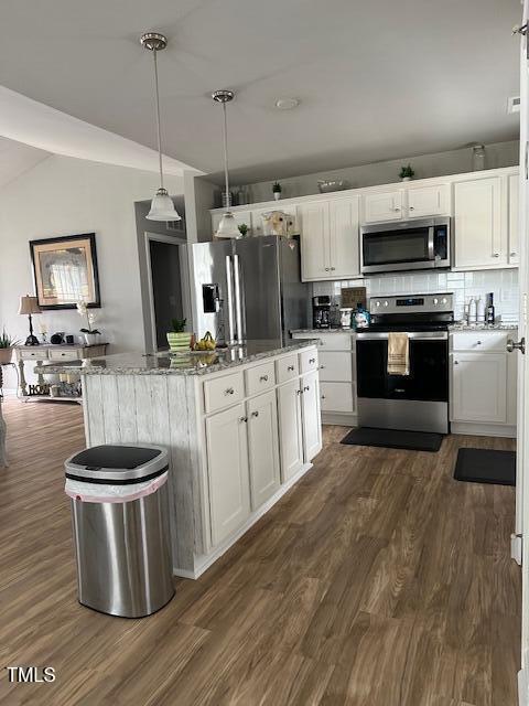 kitchen with decorative light fixtures, tasteful backsplash, white cabinetry, a center island, and stainless steel appliances