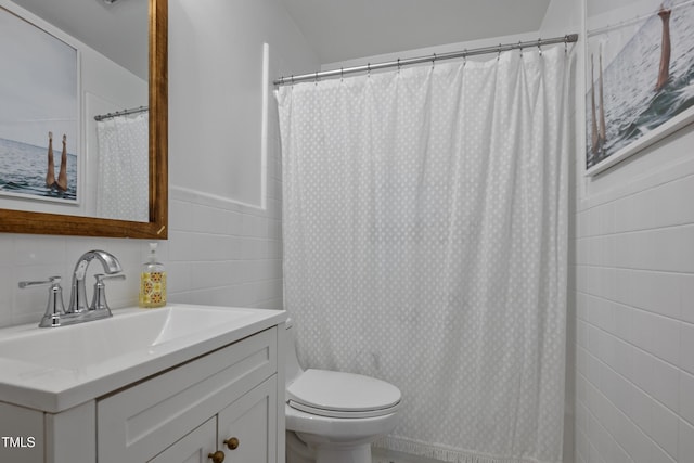 bathroom featuring tile walls, toilet, a shower with shower curtain, and vanity