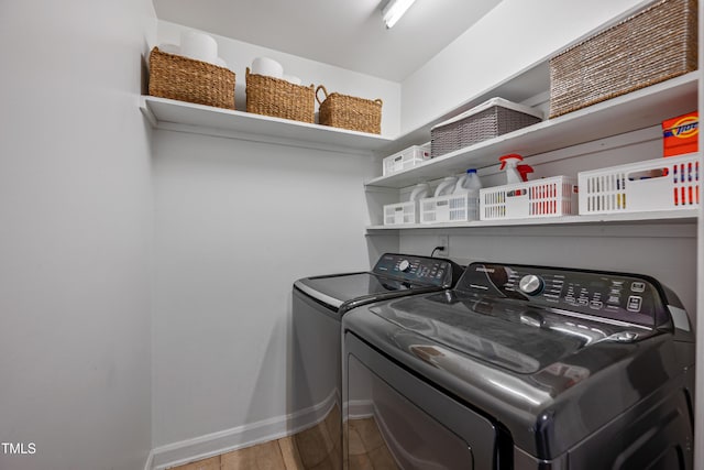 washroom with washing machine and clothes dryer and wood-type flooring