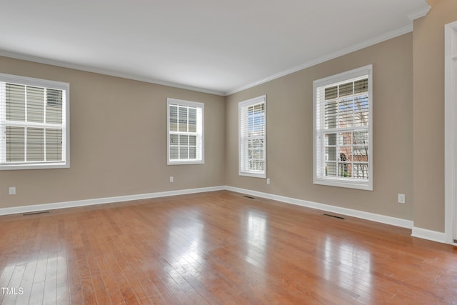 empty room with crown molding and light hardwood / wood-style flooring