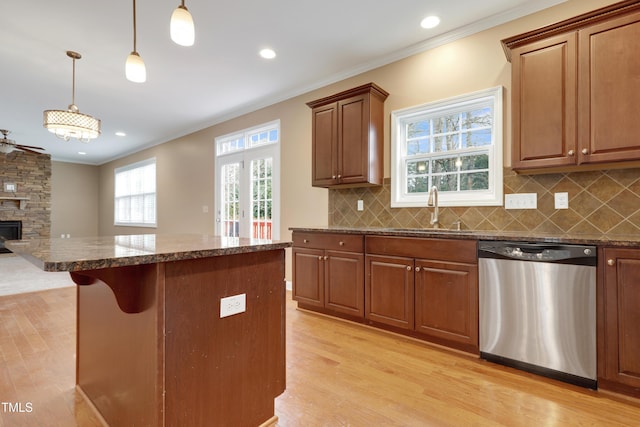 kitchen featuring pendant lighting, sink, crown molding, and dishwasher