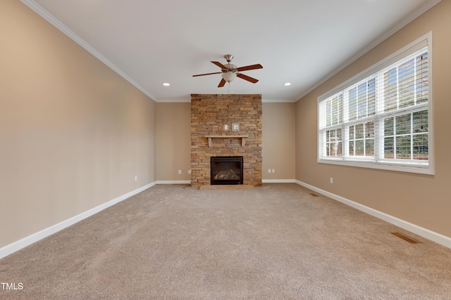 unfurnished living room with ceiling fan, ornamental molding, a fireplace, and light carpet