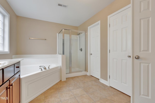 bathroom with tile patterned flooring, vanity, and plus walk in shower