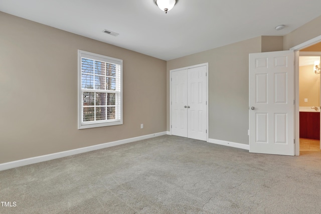 unfurnished bedroom with a closet and light carpet