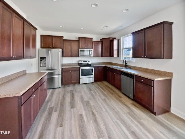 kitchen with light hardwood / wood-style floors, sink, and stainless steel appliances