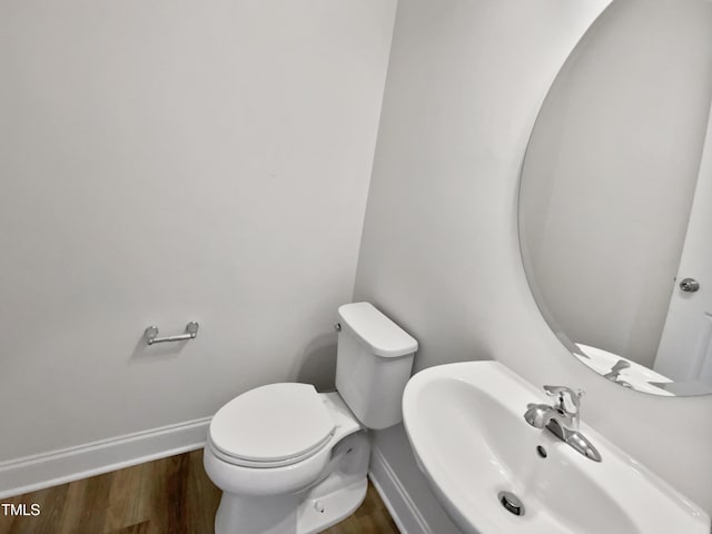 bathroom with hardwood / wood-style flooring, toilet, and sink