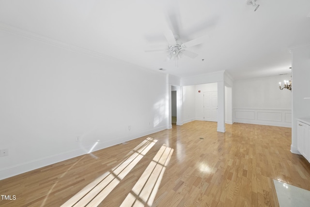 unfurnished living room featuring ceiling fan with notable chandelier, light hardwood / wood-style flooring, and crown molding