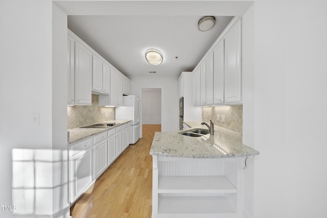 kitchen with white cabinets, black electric stovetop, tasteful backsplash, and sink