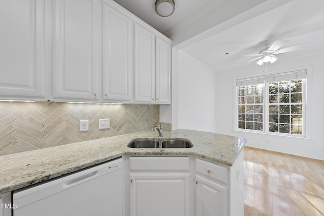 kitchen featuring dishwasher, white cabinetry, decorative backsplash, sink, and light stone counters