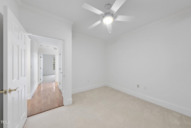 carpeted empty room featuring crown molding and ceiling fan