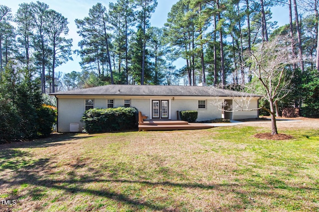 ranch-style house featuring a wooden deck and a front yard