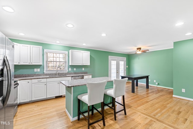 kitchen with a center island, sink, and white cabinets