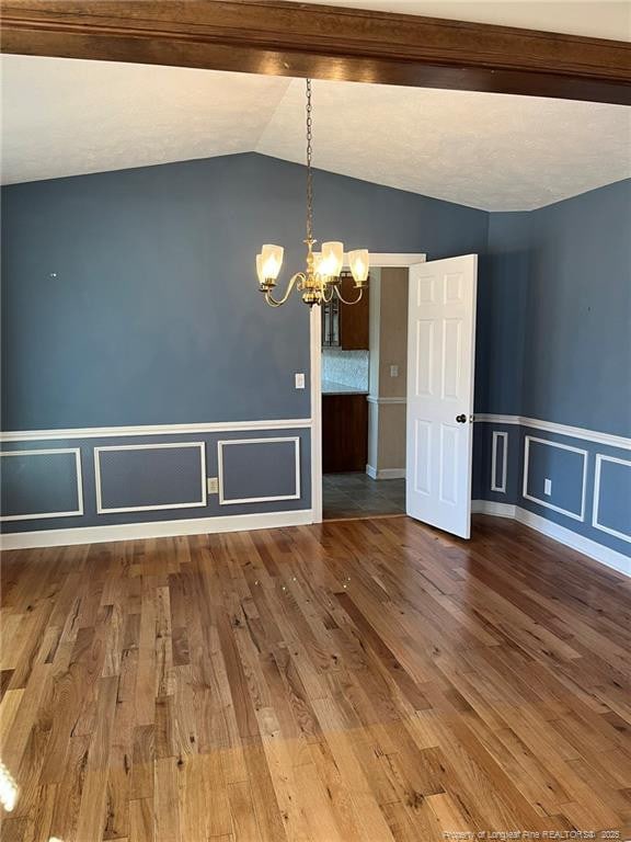 interior space with a chandelier, wood-type flooring, and vaulted ceiling with beams