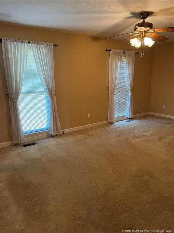 carpeted spare room featuring ceiling fan