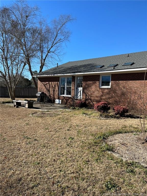 rear view of house with a patio area and a lawn