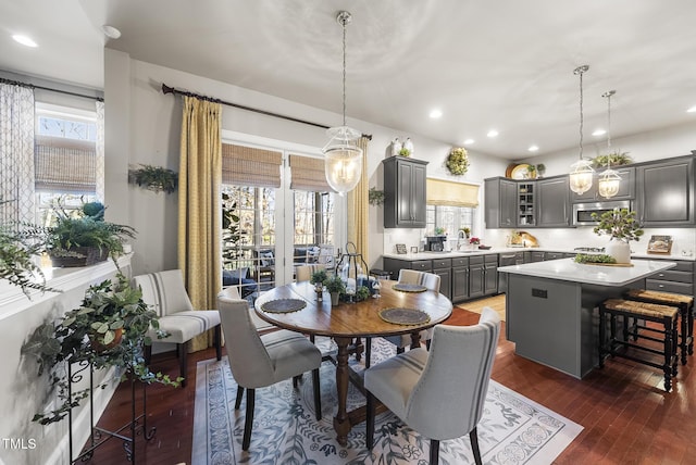 dining area featuring sink, dark wood-type flooring, and plenty of natural light