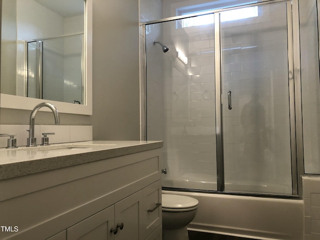 full bathroom with vanity, toilet, and enclosed tub / shower combo