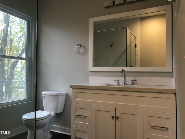 bathroom with toilet, an enclosed shower, and vanity