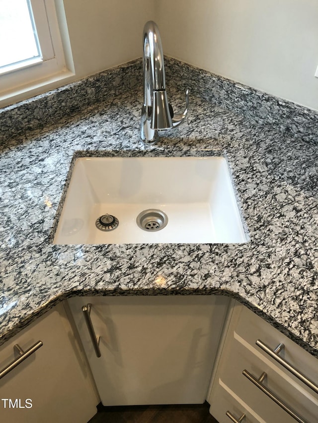 room details with dark stone countertops and sink