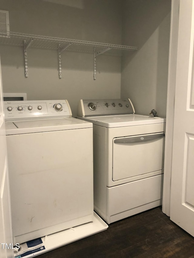 clothes washing area featuring dark hardwood / wood-style floors and washing machine and clothes dryer