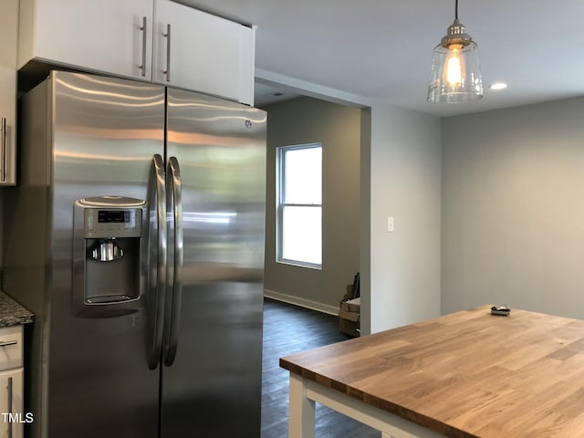 kitchen with white cabinets, butcher block counters, stainless steel refrigerator with ice dispenser, and hanging light fixtures