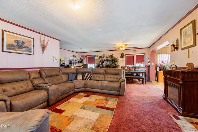 carpeted living room with ceiling fan, ornamental molding, and a textured ceiling