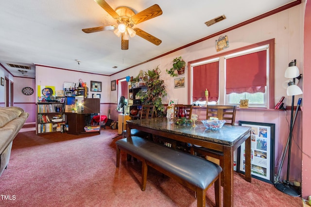 carpeted dining space with ceiling fan and crown molding