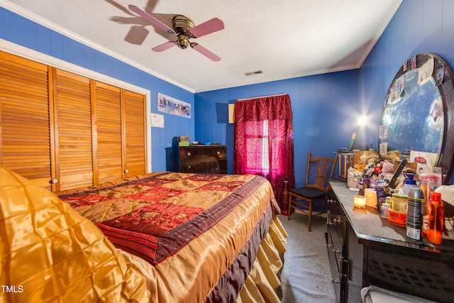 carpeted bedroom with a textured ceiling, a closet, ceiling fan, and crown molding