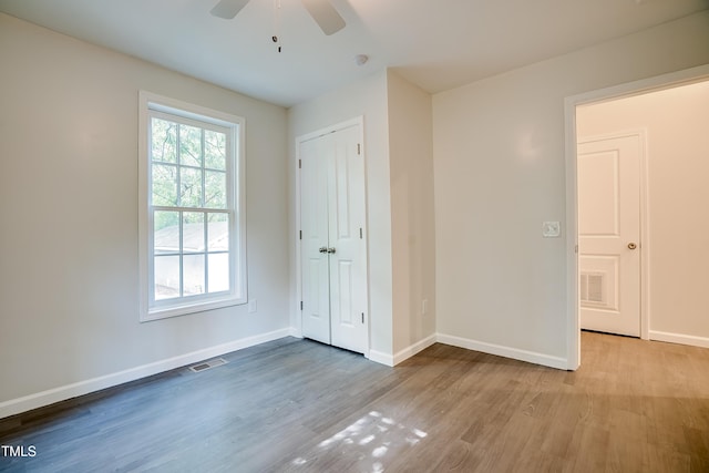 unfurnished bedroom featuring ceiling fan, light hardwood / wood-style flooring, and a closet