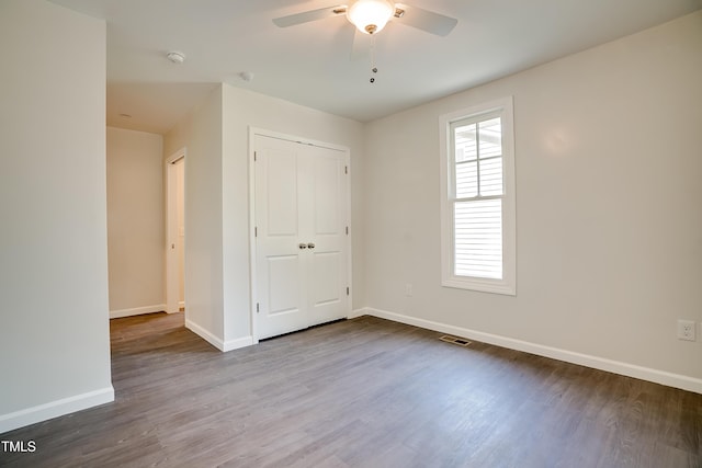 unfurnished bedroom with wood-type flooring, a closet, and ceiling fan